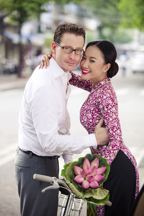 Trong buổi chụp ảnh cưới, ca sĩ Đoan Trang mặc áo dài hoa lạ mắt, kiểu dáng đơn giản và nhẹ nhàng. Màu áo dài nổi bật, đồng điệu với hoa sen cầm tay và cô dâu chọn trang điểm tông hồng rực rỡ.
