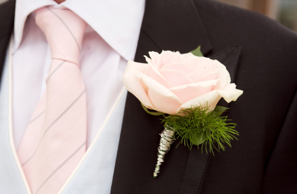 Một bông hoa hồng duy nhất cài lên áo, hợp tông với màu cravat sẽ là điểm nhấn cho chú rể.