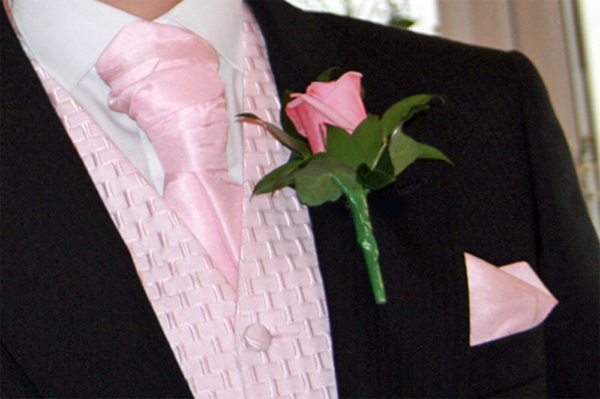 Bông hoa cùng tông hoàn toàn với cravat, sơ mi và chiếc khăn cài áo.